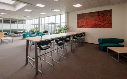 Místnost s dlouhým stolem a bílými židlemi